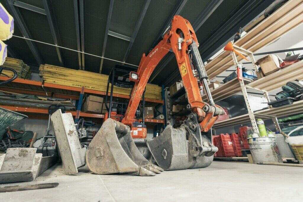 Une pelleteuse stockée dans un hangar de chantier